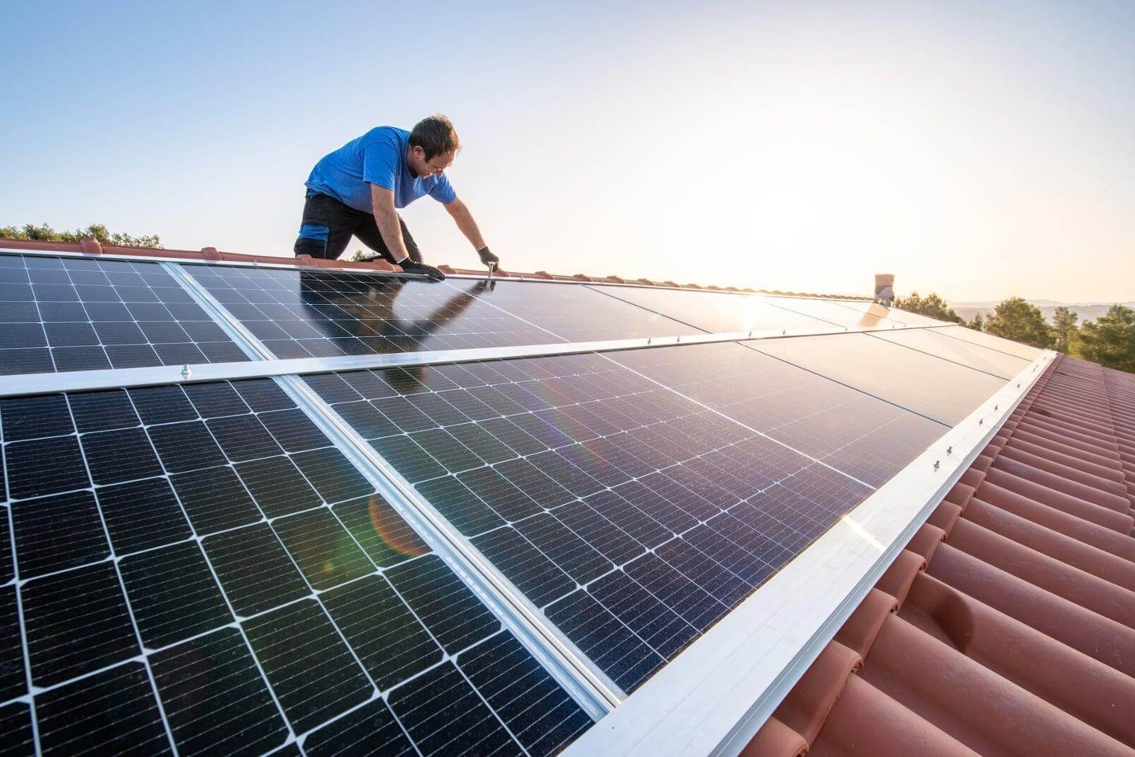 man on roof installing solar panel